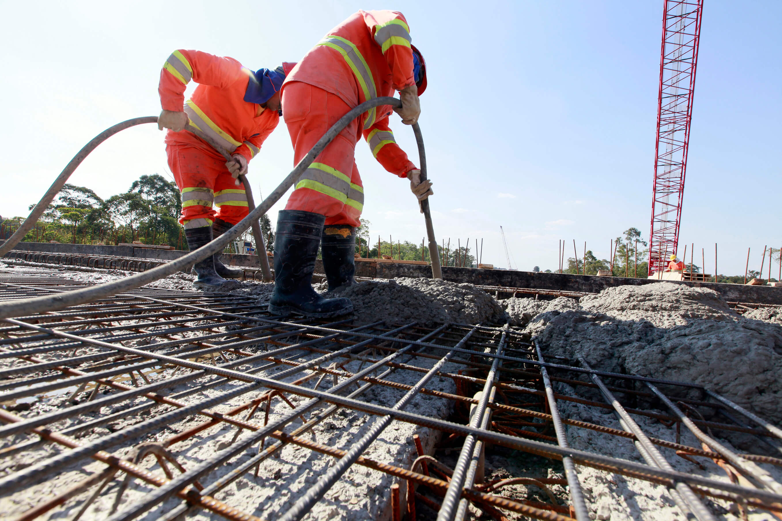 Construction workers laying concrete within a precast formwork