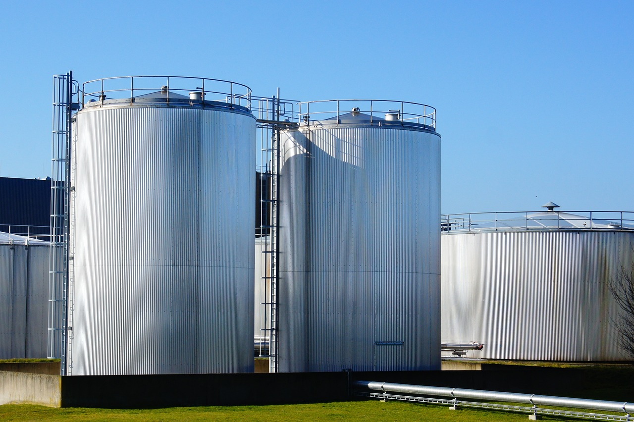 Three storage tanks outside of a factory facility.